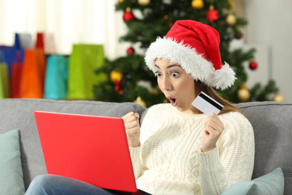 An excited girl in front of a laptop having won a reward.