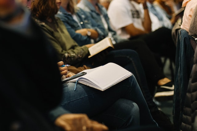 People with their notebooks out participating in employee trianing and development initiatives.