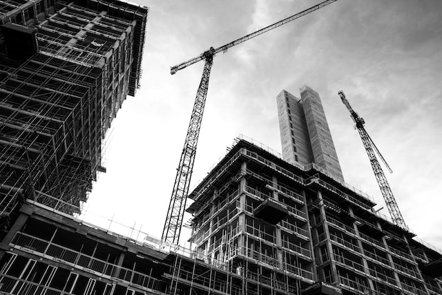 A construction site of a tall building in black and white. 