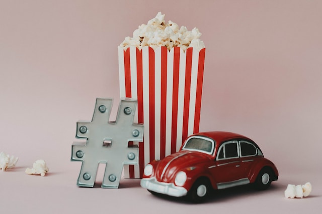 A hashtag sign next to popcorn and a toy car. Strategic hashtags are essential in social media strategies for businesses.