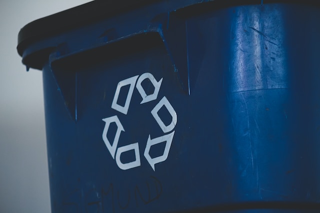 A blue recycle bin which can be part of sustainable practices in businesses